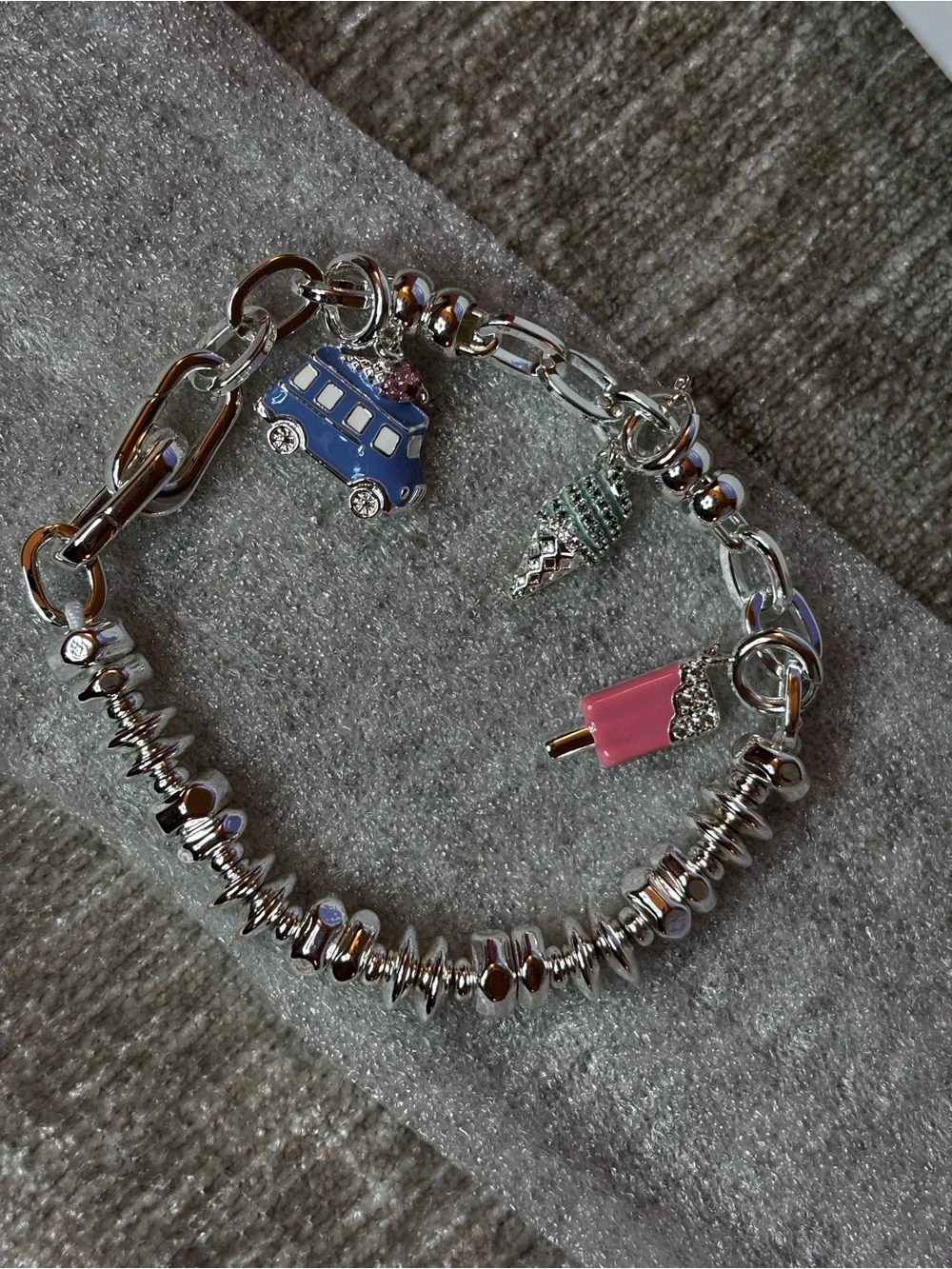 Silver plated charm bracelet with three removable charms.